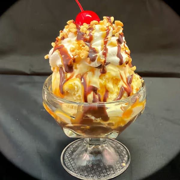 A Myra Jean's vanilla ice cream sundae with whipped cream, chocolate, caramel, nuts, and a cherry.